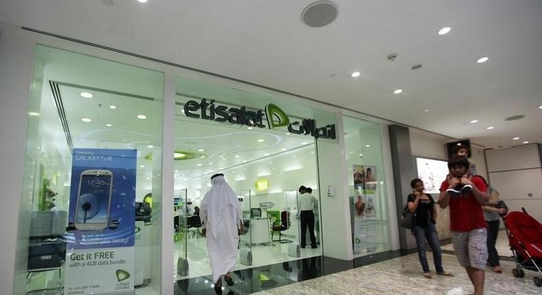 Customers walk past an Etisalat store at a shopping mall in Dubai, July 10, 2012.  REUTERS/Jumana El Heloueh