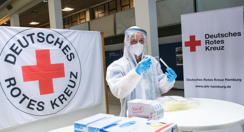 An employee of the German Red Cross (DRK) stands at a coronavirus test center at Hamburg Airport in 2020.Daniel Bockwoldt/picture alliance via Getty Images