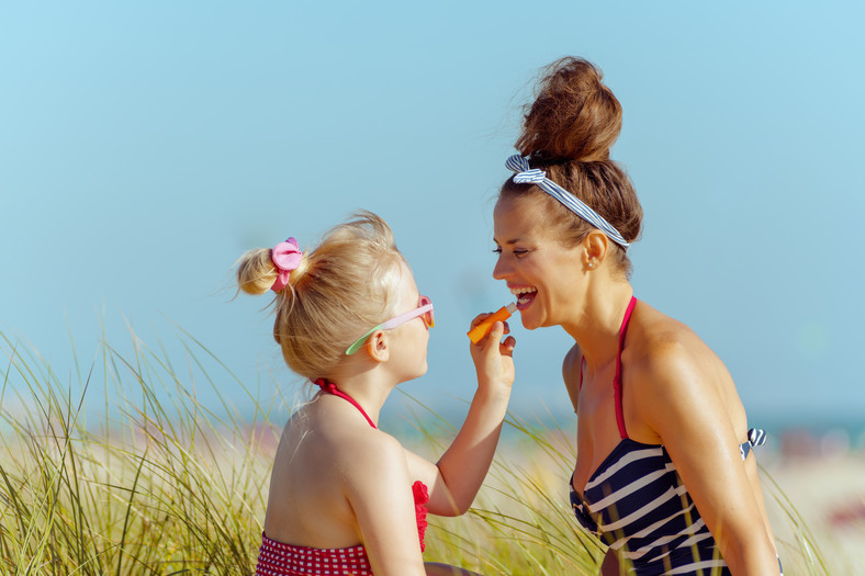 Mama z córką używają pomadki z filtrem SPF