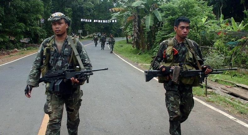 Philippine marines patrol a road on Basilan island, stronghold of the notorious Abu Sayyaf kidnap-for-ransom group, who killed nine in a dawn attack Monday according to police