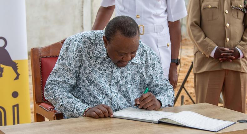 President Uhuru Kenyatta signs a visitors' book after inspecting Kenya's first Agri Hub, an Eni Kenya vegetable oil and related bio-products factory in Wote, Makueni County on August 4, 2022