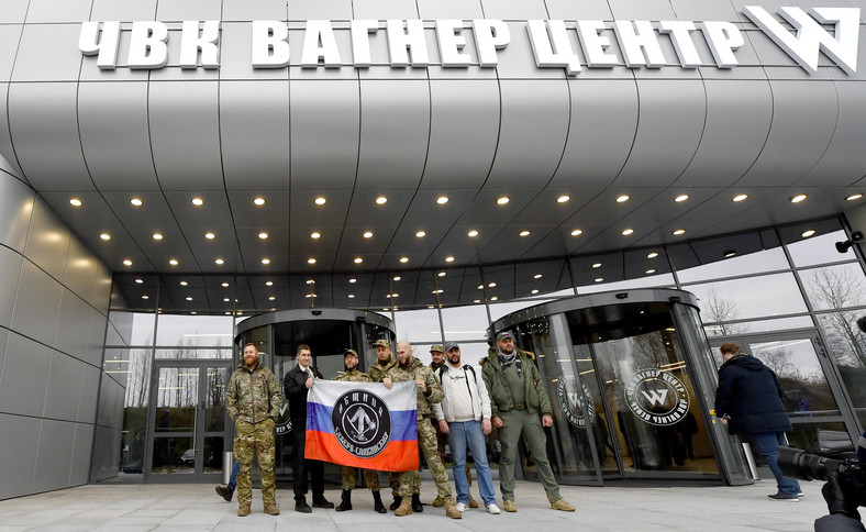 Zwiedzający w wojskowym kamuflażu pozujący przy wejściu do "Centrum Grupy Wagnera", w Sankt Petersburgu, 4 listopada 2022 r.