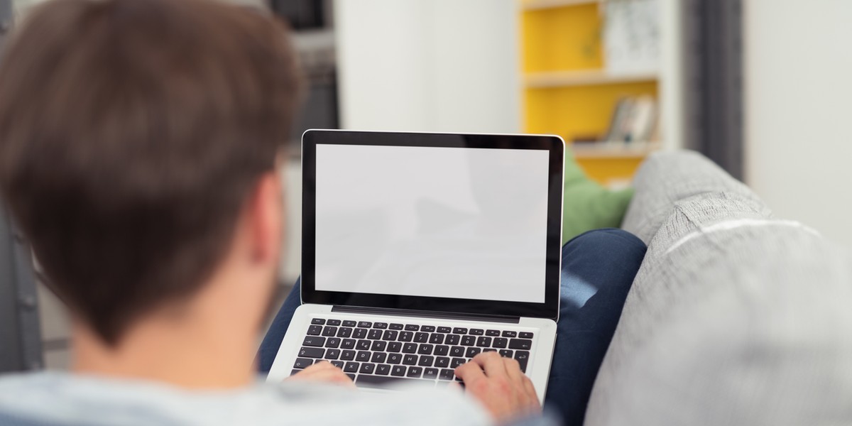 Man Relaxing on Sofa with Laptop Computer