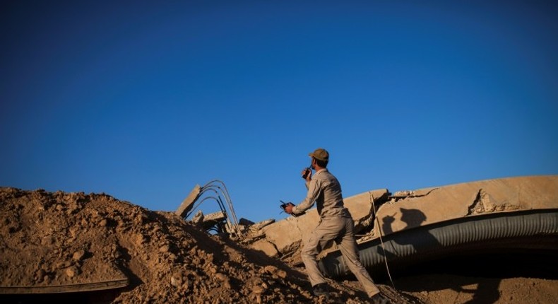 An Iraqi militia member checks the position of an Islamic State sniper at Tal Afar airport