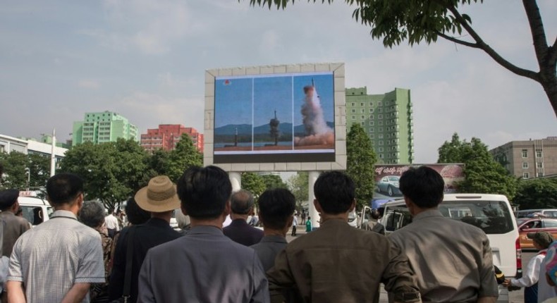 People watch a screen showing coverage of the Pukguksong-2 missile launch, in central Pyongyang on May 22, 2017