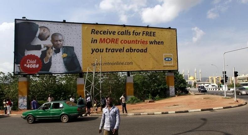 A man walks in front of an advertisement billboard of MTN phone company in Abuja, Nigeria May 25, 2015. 