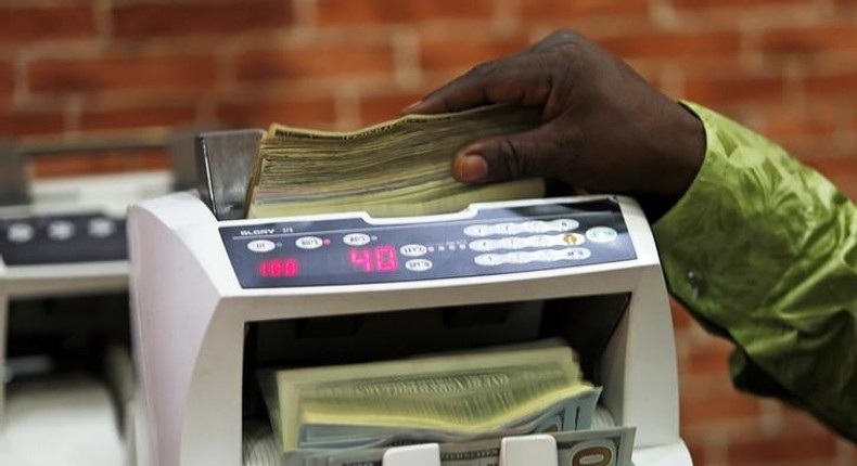 A bureau de change operator counts U.S. currency notes in Abuja, March 12, 2015. Picture taken March 12, 2015. REUTERS/Afolabi Sotunde (NIGERIA - Tags: BUSINESS POLITICS)