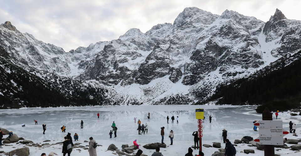 Turyści na tafli lodu na jeziorze Morskie Oko w Tatrach