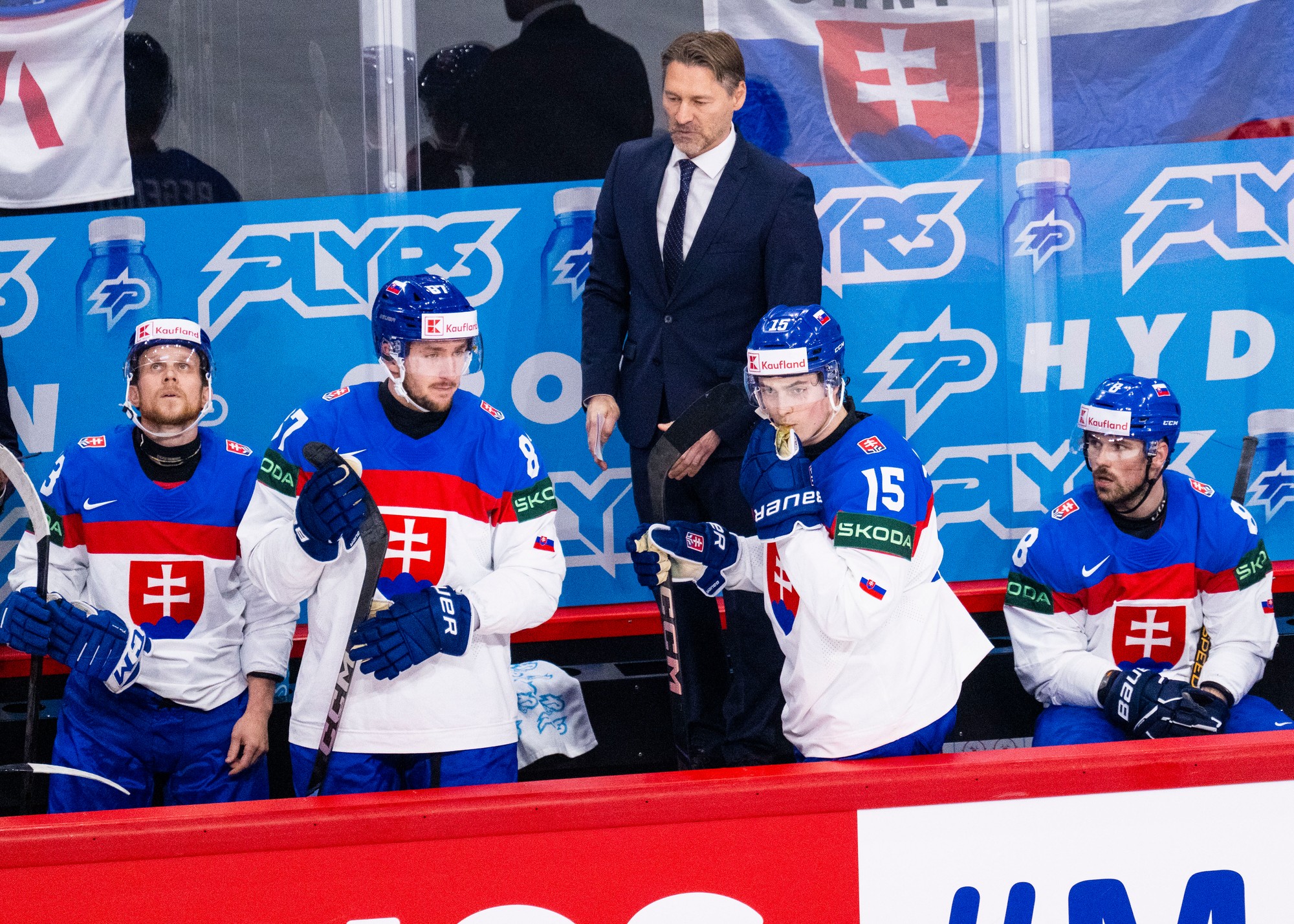 Slovenskí hokejisti zľava Michal Krištof, Pavol Regenda, tréner slovenskej hokejovej reprezentácie Vladimír Országh, Dalibor Dvorský a Maxim Čajkovič sledujú zo striedačky zápas. 
