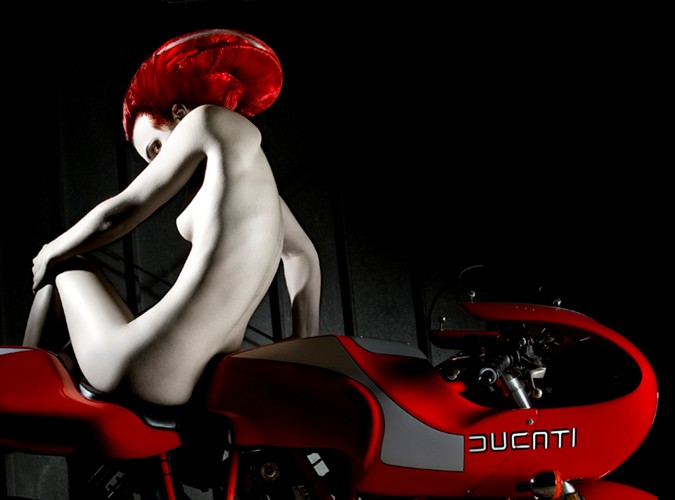 Naga kobieta i Ducati. Autorką zdjęć jest młoda artystka fotografii, Elizabeth Raab - jej specjalnością są kreatywne portrety. Ze zdjęć wykonanych jej ręką biją silne emocje. Fotografie, które możecie obejrzeć w naszej galerii można kupić w większych rozmiarach na stronie Ducati Art.