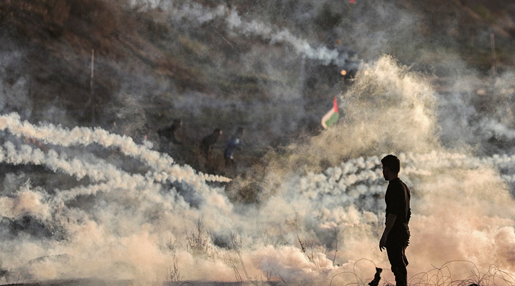 Palesztin tüntetők izraeli katonák által kilőtt könnygázgránátok elől futnak a Gázai övezet határkerítésénél 2019. december 20-án. / Fotó: MTI/EPA/Mohamed Szaber