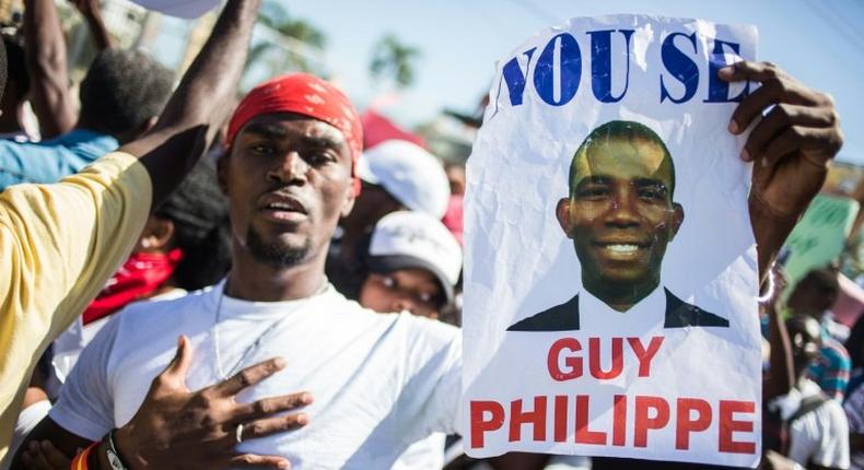 A supporter of Guy Philippe holds a sign during protests in front of the US embassy in Tabarre, Haiti in January 2017