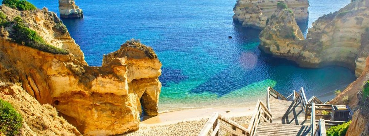 Zobacz wspaniałe zachody słońca w Lagos Wiele pięknych miast i miasteczek Algarve zostało w większym lub mniejszym stopniu zniszczone podczas trzęsienia ziemi w 1755r. Ucierpiało, między innymi wiele budynków Lagos, które z tego powodu utraciło swój status stolicy regionu. Kataklizm oszczędził jednak kilka ciekawych obiektów, jak Fort Ponta da Bandeira z XVII-wieku, a powstały już w późniejszym okresie Kościół św. Antoniego (Igreja de Santo António) uchodzi za architektoniczny klejnot. Największym atutem miasta jest jego położenie. Część Algarve w której znajduje się Lagos uznawana jest za najpiękniejszą, głównie ze względu na malownicze wybrzeże i słynne plaże. To tutaj znajduje się stworzona do wypoczynku, szeroka i piaszczysta Meia Praia. Porto do Mos, otoczona przez skalne klify, to z kolei idealne miejsce do podziwiania wspaniałych zachodów słońca. A złociste Praia Dona Ana, Camilo, czy Meia Praias oblane przez krystaliczne wody kameralnych zatoczek, słyną z zapierających dech w piersi skalnych formacji tworzących malownicze labirynty i przejścia pośród błękitnych wód. Niesamowitych widoków dostarczy także skalisty cypel Ponta da Piedade. Świadomość tego, że stoi się na krawędzi nad oceanem to naprawdę niezapomniane wrażenie. Na zdjęciu: Praia do Camilo w pobliżu Lagos Czytaj więcej na r.pl >>