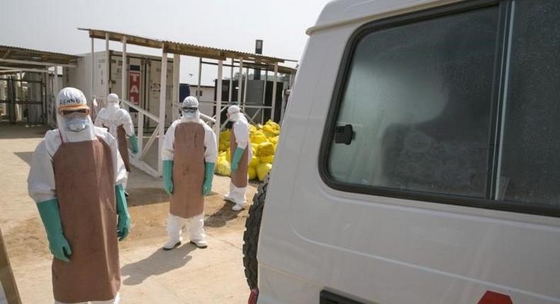 Healthcare workers prepare to disinfect an ambulance transporting a newly admitted Ebola patient at the entrance to the Save the Children Kerry Town Ebola treatment centre outside Freetown, Sierra Leone, December 22, 2014. REUTERS/Baz Ratner