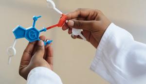 A student holding a chemistry molecule model [Image Credit: RF Studio]