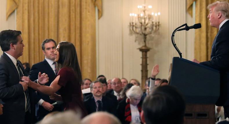 A White House staff member reaches for the microphone held by CNN's Jim Acosta as he questions U.S. President Donald Trump during a news conference following Tuesday's midterm U.S. congressional elections, in a combination of photos at the White House in Washington, U.S., November 7, 2018.