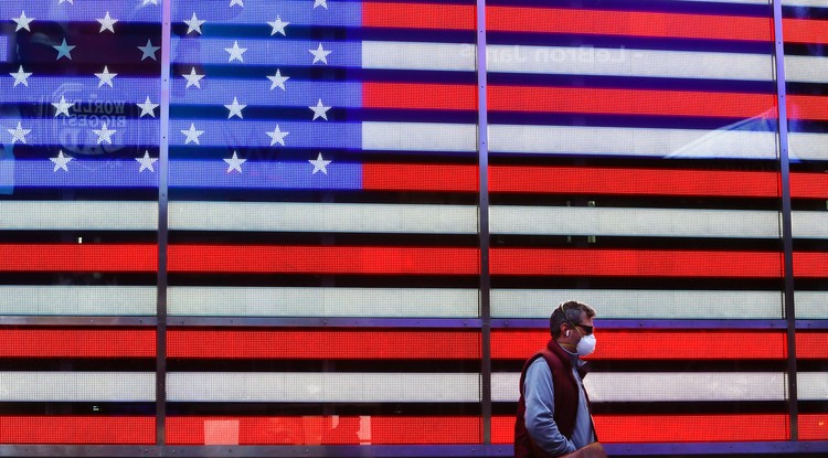 A koronavírus-járvány miatt védőmaszkot viselő férfi megy a New York-i Times Square-en 2020. április 22-én.