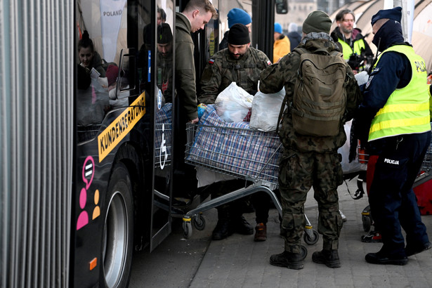 Żołnierze i policjanci pomagają uchodźcom z Ukrainy po przekroczeniu polsko-ukraińskiego przejścia granicznego w Medyce