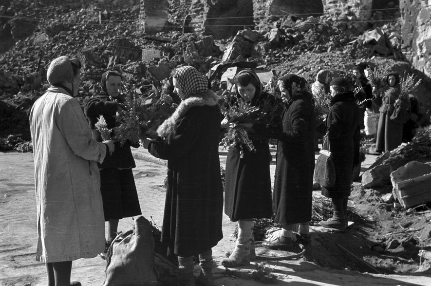 Sprzedaż palm wielkanocnych przed zrujnowanym kościołem pw. Świętego Krzyża w Warszawie (1945)