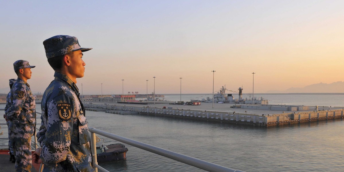 Chinese naval soldiers stand guard on China's first aircraft carrier Liaoning, as it travels towards a military base in Sanya, Hainan province.