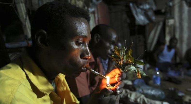 Somali men smoke and chew khat inside a makeshift building at night in Mogadishu August 6, 2014. REUTERS/Feisal Omar