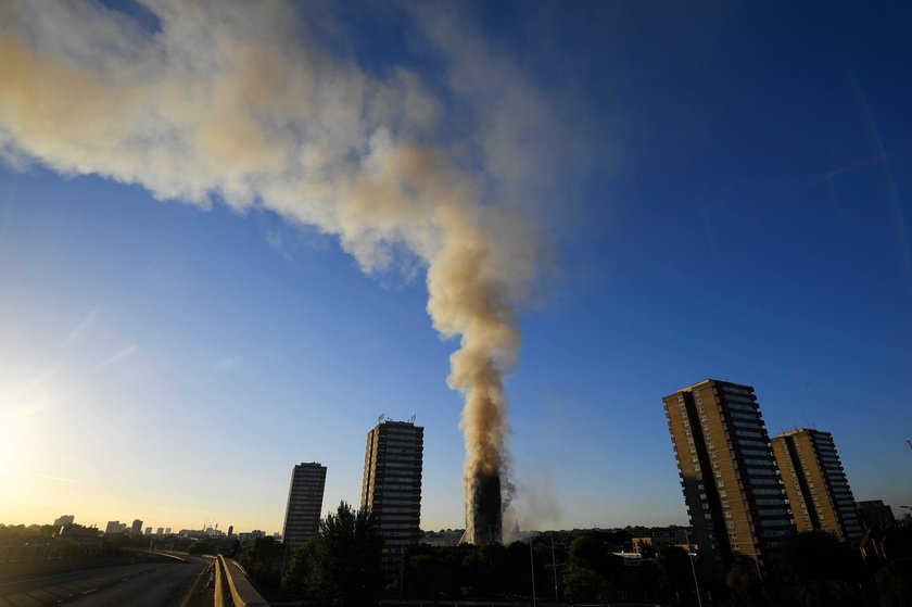 Flames and smoke billow as firefighters deal with a serious fire in a tower block at Latimer Road in