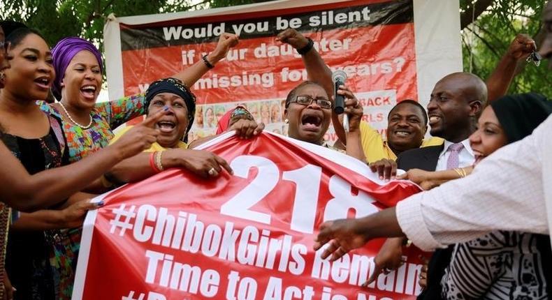 Members of the #BringBackOurGirls (#BBOG) campaign react on the presentation of a banner which shows 218, instead of the previous 219, referring to kidnapped Chibok school girls, during a sit-out in Abuja, Nigeria May 18, 2016, after receiving news that a Nigerian teenager kidnapped by Boko Haram from her school in Chibok more than two years ago has been rescued. 