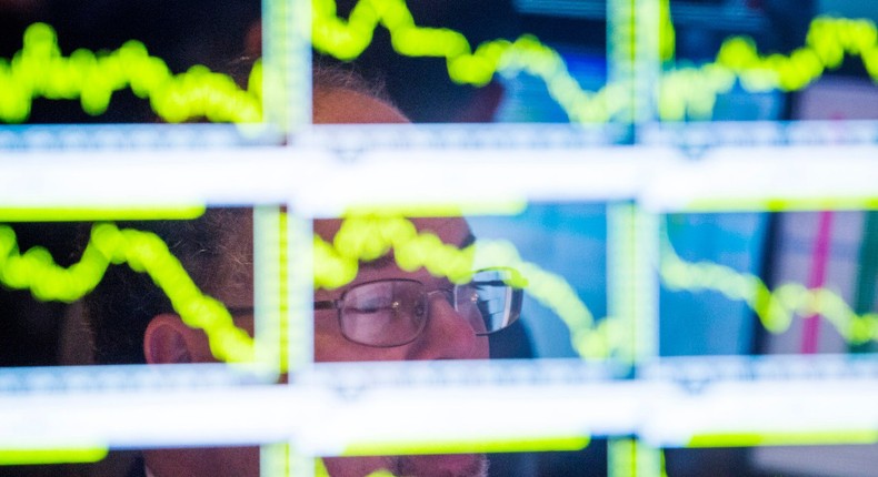 A trader looks up at charts on his screen just before the end of trading for the day on the floor of the New York Stock Exchange, November 18, 2013.