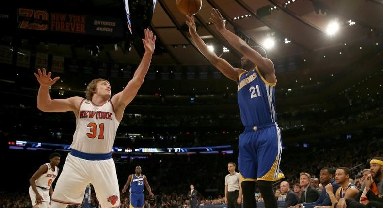 Ron Baker (L) of the New York Knicks tries to block a shot from Ian Clark of the Golden State Warriors at Madison Square Garden on March 5, 2017