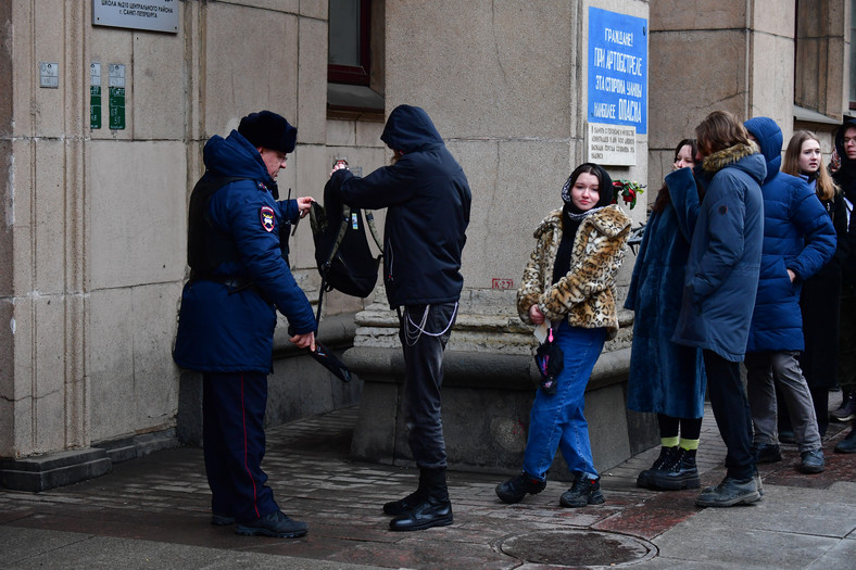 Policja sprawdza Rosjan, którzy stoją w kolejce przed lokalem wyborczym podczas wyborów prezydenckich w Rosji, Petersburg, 17 marca 2024 r.