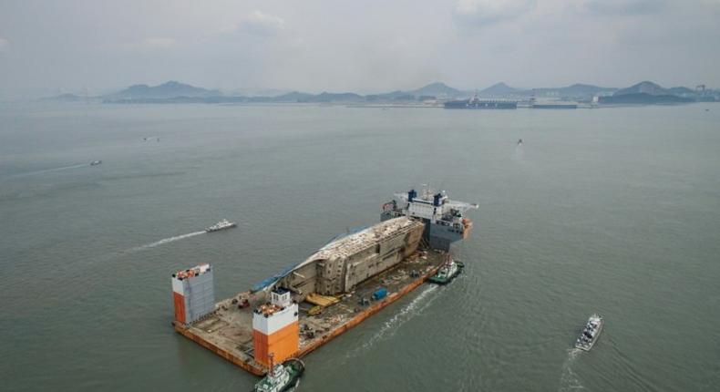 The wreck of the Sewol ferry arrives at a port in Mokpo on a semi-submersible ship in March