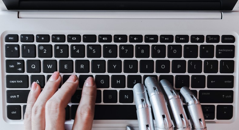 Robot and human hands share a keyboard.sompong_tom/Getty Images