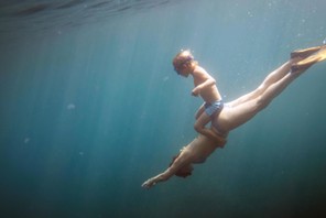 Underwater view of boy and mother diving