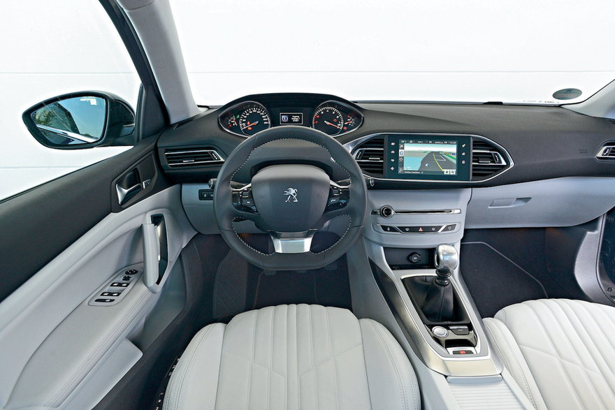 Mała kierownica z umieszczonymi ponad nią zegarami (obrotomierz – „pod prąd”) i sterowanie klimatyzacją przeniesione na centralny ekran dotykowy (Peugeot nazywa to „i-Cockpit”)