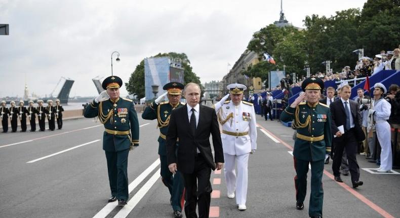 Russia's President Vladimir Putin (centre) walks with officials as he attends a ceremony for Russia's Navy Day in Saint Petersburg on July 30, 2017