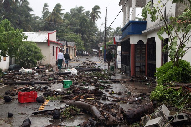 People walk on a street covered in debris as Hurricane Irma moves off from the northern coast of the