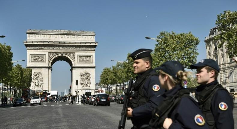 French Police officers patrol the Champs Elysees avenue near the Arc de Triomphe monument in Paris on April 21, 2017, a day after a gunman opened fire on police nearby on the avenue, killing a policeman and wounding two others