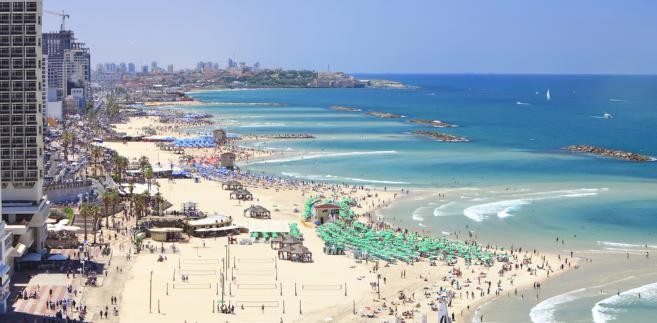 Tel Awiw<br><br>To kolejny kierunek z serii uciekam na chwilę od chłodu. W październiku nadal panują wysokie temperatury, ale czuć, że nie jest to ten sam żar, co w miesiącach letnich. Tel Awiw to miasto, w którym znajdziesz wiele rozrywek, ale przede wszystkim możesz wylegiwać się całe dnie na pobliskich, piaszczystych plażach. Do woli objesz się tu kebabami lub falafelami czy hummusem (szczególnie zachwalany jest ten w starszej części miasta, Jaffie), jeśli wolisz opcję wege. Na plaży Ga’ash, oddalonej około pół godziny drogi na północ od Tel Awiwu, odnajdziesz zarówno piękno przyrody, jak i odrobinę luzu i swobody. Sprawdzi się też do biegania, natomiast by pograć w siatkówkę wybierz plażowe boiska na Gordon Beach. Tel Awiw możesz potraktować też jako początek swojej wycieczki po Izraelu – czekają na Ciebie jeszcze bardziej ortodoksyjna Jerozolima lub słoneczny Ejlat.