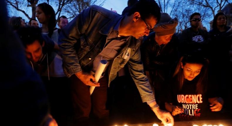 Demonstrators light candles during a protest in Paris over the death of Chinese Liu Shaoyo, shot dead by French police