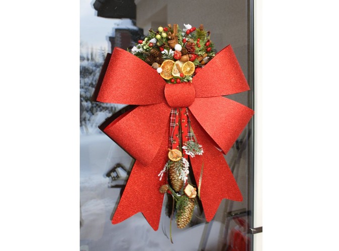 Stroik okienny ze świątecznymi dekoracjami i wielką, czerwoną kokardą. Autorka: Marta Jarosińska-Mańka