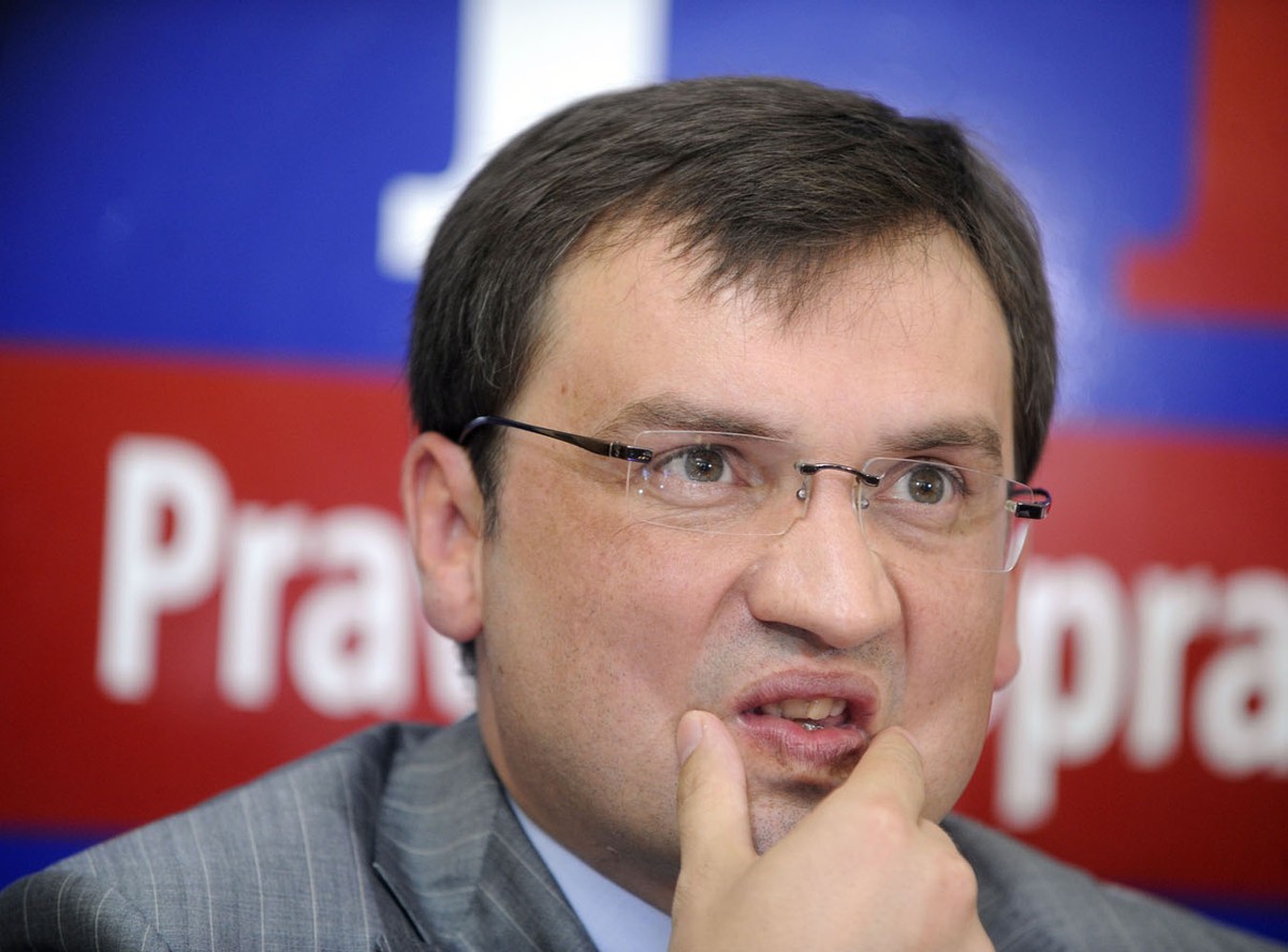 Zbigniew Ziobro na tle plakatu Prawa i Sprawiedliwości