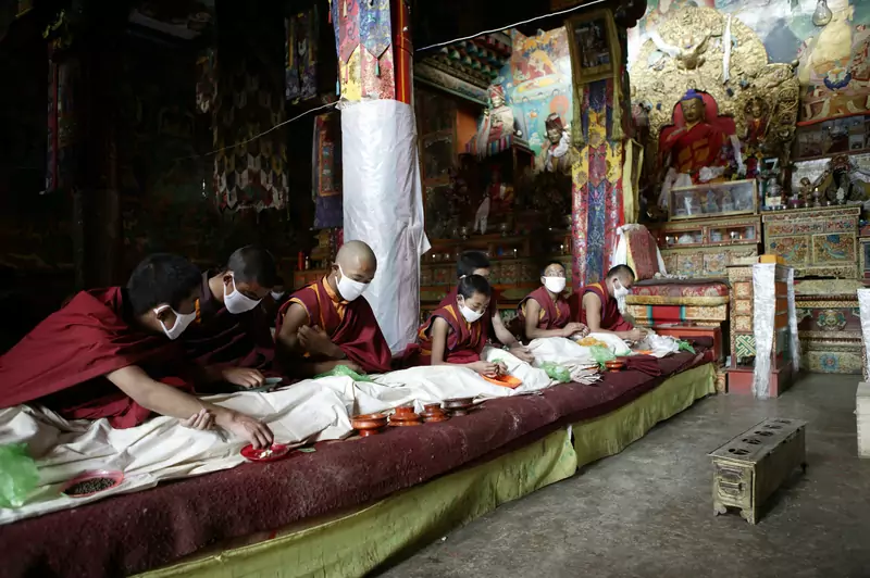 Buddyjscy mnisi modlą się w świątyni, Tybet / Getty Images