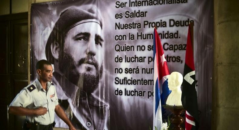 A police officer passes by a large portrait of late Cuban revolutionary leader Fidel Castro at the City Hall of the Guanabacoa municipality in Havana, on November 28, 2016