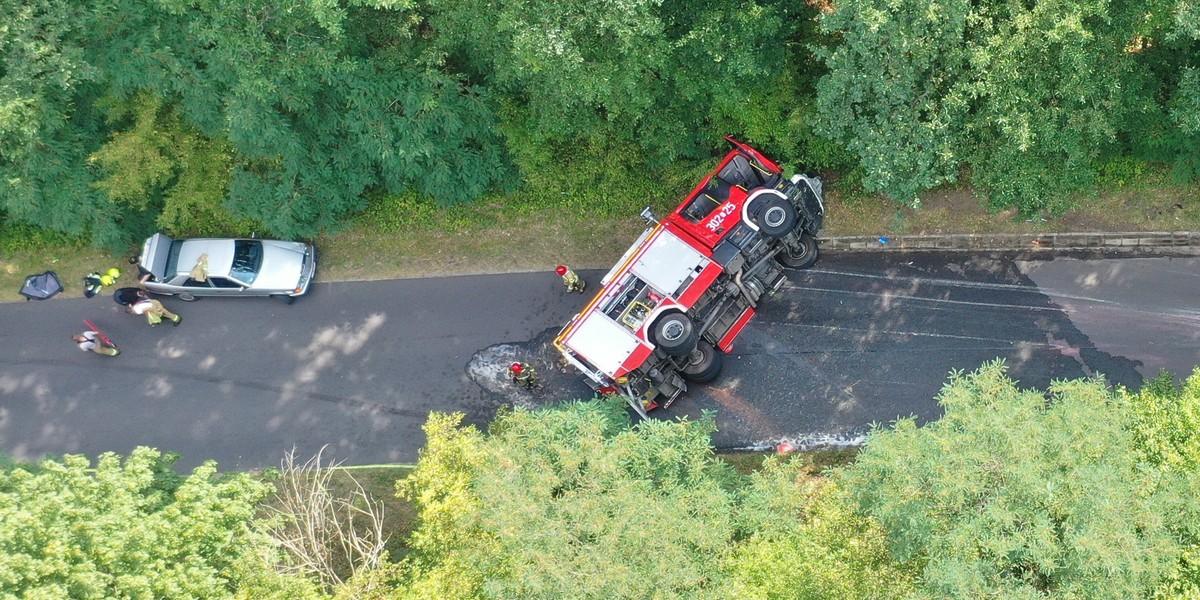 Wypadek wozu strażackiego. Leży na boku. 