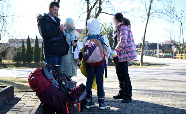 Rodzina ukraińskich uchodźców ze Lwowa, która opuściła swój kraj w obawie o bezpieczeństwo dzieci, oczekująca na pomoc w pobliżu polsko-ukraińskiego przejścia granicznego w Medyce
