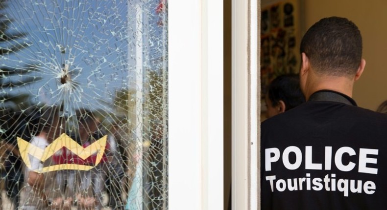 A Tunisian police officer stands guard near a bullet hole at the the Riu Imperial Marhaba Hotel after an attack that left 38 people dead on June 25, 2015