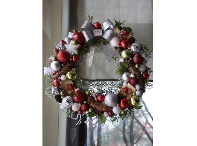 Bożonarodzeniowy wianek ze srebrnymi, zielonymi i czerwonymi dekoracjami, ozdobiony kokardą. Autorka: Marta Jarosińska-Mańka