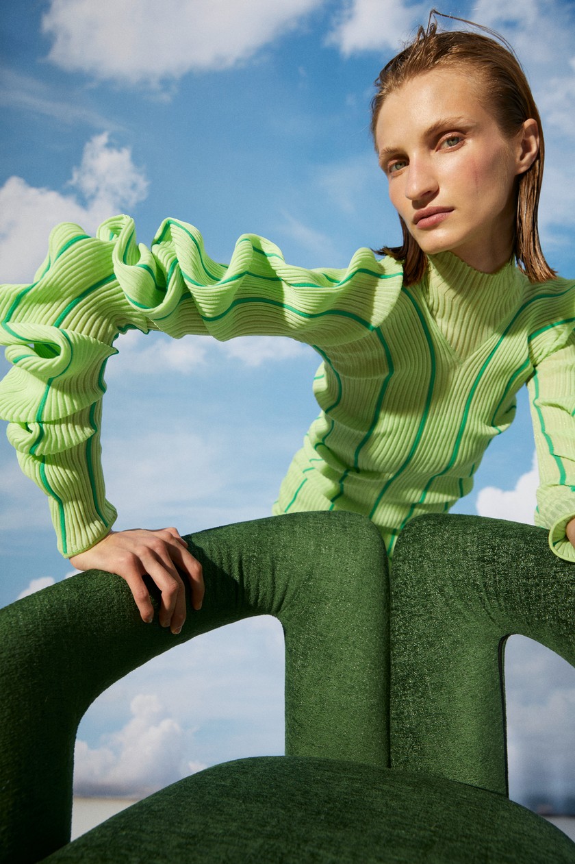 BOTTEGA VENETA Kleid aus gerippter Seide mit spiralförmigen Ärmeln. Cassina  Armlehnstuhl Dudet mit Tessuto-L-Bezug im Farbton Bosco Green.