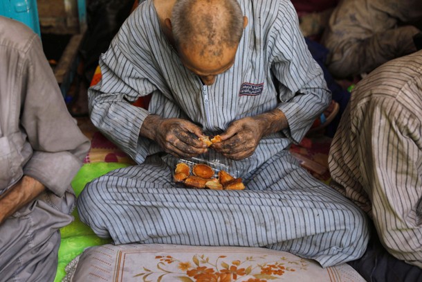 A displaced Iraqi man who was among the rescued at the site of battle eats bread at the positions of