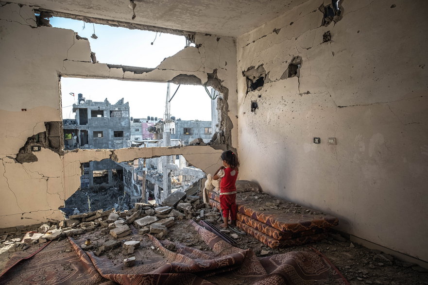Dziewczynka w zniszczonym mieszkaniu w Bajt Hanun w Strefie Gazy